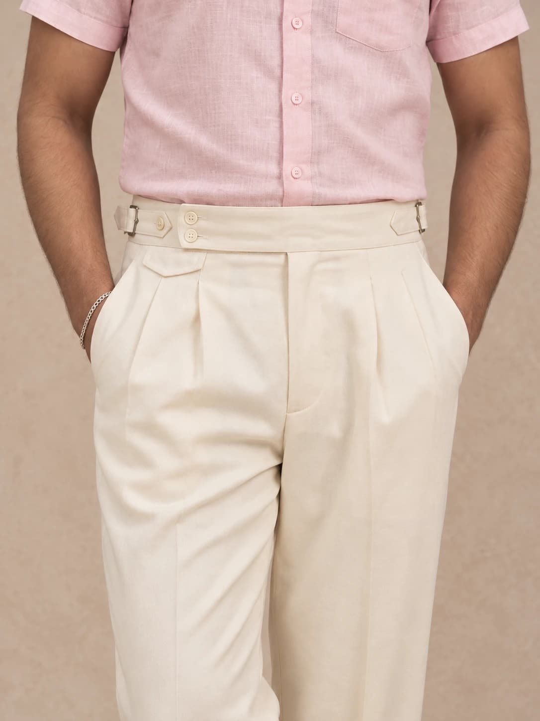 Cream pleated trousers — front view with side-adjuster waistband