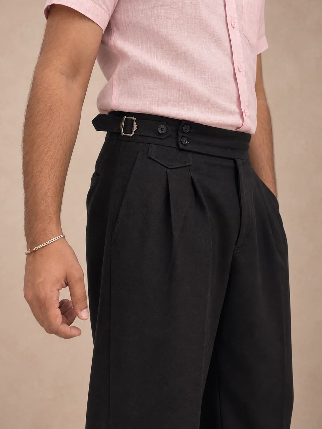 Black pleated trousers — detail view