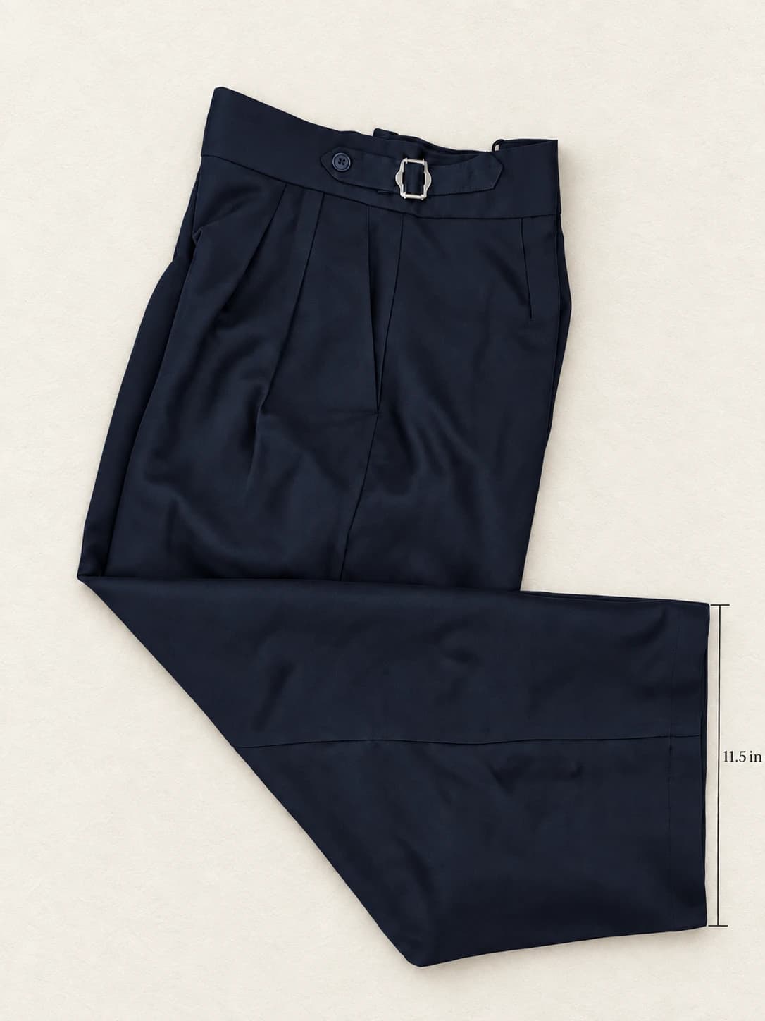 Navy blue pleated trousers folded flat, 11.5 inch leg opening